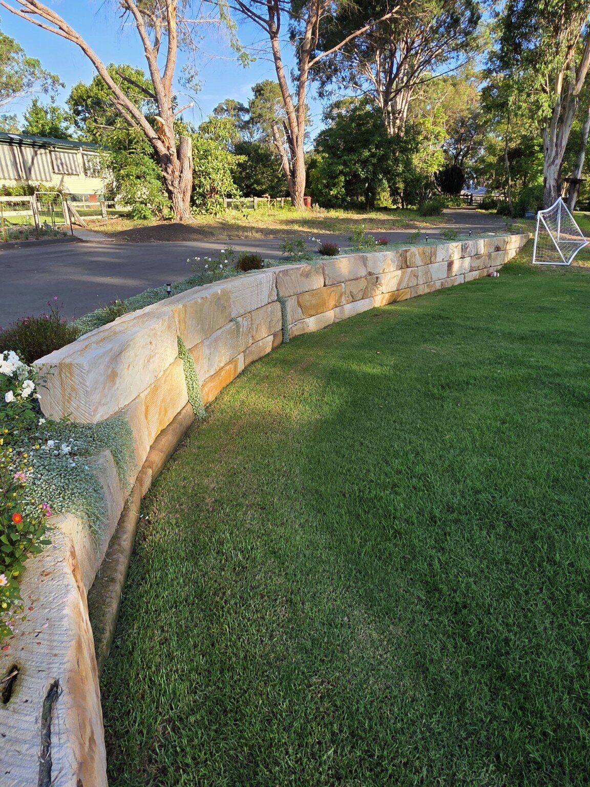 Completed sandstone and lawn landscape by Moores Trades and Services